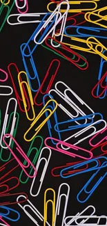 Colorful paperclips scattered on a black background, vibrant mobile wallpaper.