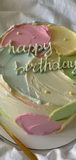 Vibrant pastel birthday cake with colorful icing swirls and 'happy birthday' text.