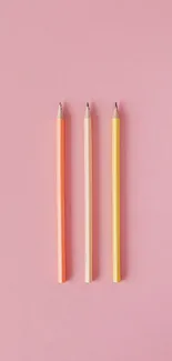 Three colorful pencils on a pink background, perfect as a phone wallpaper.