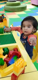 Child playing in colorful toy area with building blocks.