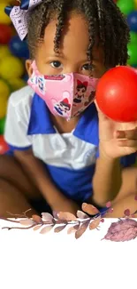 Child with red ball in colorful ball pit.