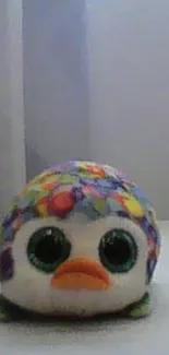 Colorful plush toy with big eyes and vibrant pattern.