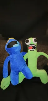 A playful blue and green plushie duo on a dark background.