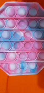 Colorful Pop It toy wallpaper with pink, blue, and orange hues.