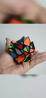 Colorful geometric puzzle cube held in hand.