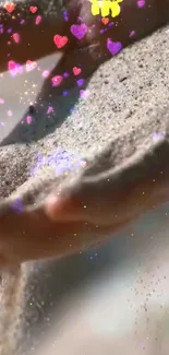 Sand flowing through hands with colorful hearts.