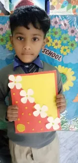 Young student with colorful art project in school setting.