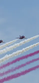 Jets streaming colorful trails across a clear blue sky.