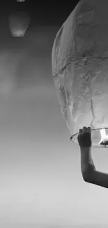 Boy releases a glowing lantern into a vibrant, colorful sunset.