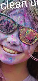 Smiling face with colorful Holi powders and sunglasses.