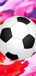 Soccer ball on a vibrant pink abstract background.