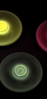 Three colorful spinning disks on black background, vibrant and dynamic design.