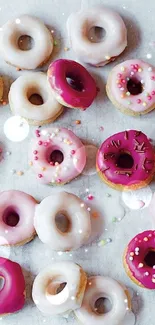 Vibrant pink and white frosted donuts with colorful sprinkles on a light background.