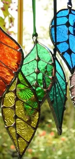 Hanging stained glass leaves in vibrant hues.