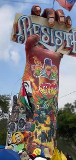 Hand holding sign with colorful graffiti art on monument.