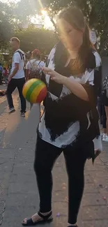 Person at a vibrant street festival holding a colorful item.