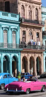 Vibrant Havana street with colorful buildings and vintage cars.