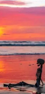 Colorful sunset with skeleton on beach.