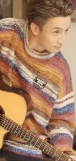 Guitarist in colorful striped sweater, striking pose.