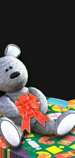 Gray teddy bear with red ribbon on colorful platform.