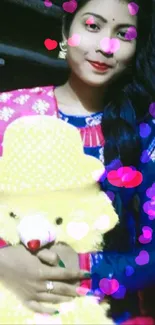 Person in blue attire holding a yellow teddy bear.