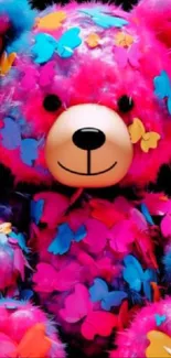 Colorful teddy bear with butterfly decorations on black background.