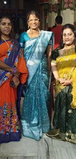 Women in traditional colorful sarees at an event.