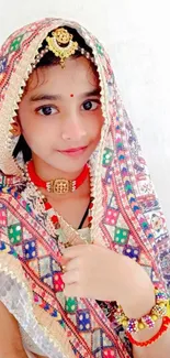 Young girl in vibrant traditional attire with colorful patterns.