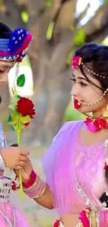 Two individuals in vibrant traditional attire holding a rose.