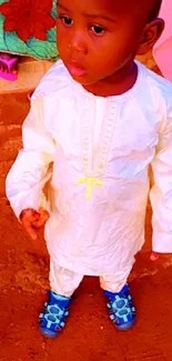 Child in colorful traditional clothes with vibrant backdrop.