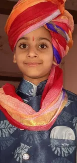 Child in colorful traditional attire with a vibrant turban.