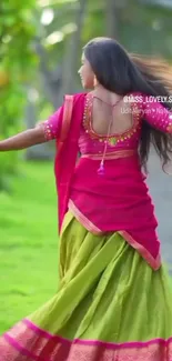 Woman in colorful traditional dress dancing outdoors with a green background.