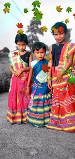 Three children in colorful traditional attire outdoors.