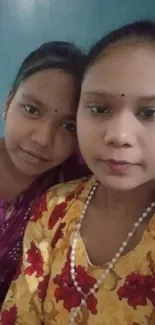 Portrait of two women in colorful traditional attire.