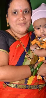 Traditional portrait of a woman with baby in colorful attire and red hues.