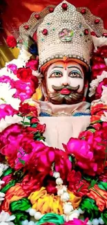 Traditional statue adorned with colorful floral garlands.