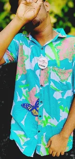 Person in colorful tropical shirt posing with peace sign.