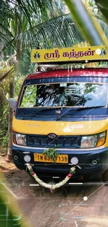 Vibrant yellow and red truck amidst green palms.