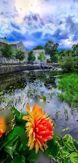 Colorful flower by a city river with cloudy sky.