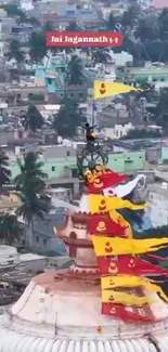 Temple adorned with colorful flags overlooking urban skyline.