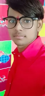 Young man in red shirt with colorful backdrop.