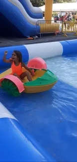 Child enjoying a colorful water ride at a fun summer park with inflatables.