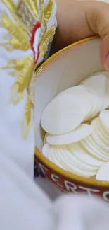 Child holding communion wafers in a bowl.