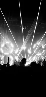 Black and white concert with lights and crowd silhouette.