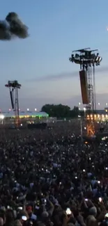 Crowd at a large outdoor concert during dusk.