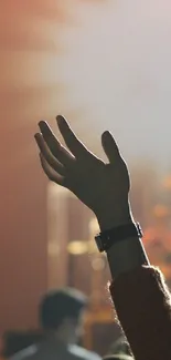 Outstretched hand at a concert under stage lights.