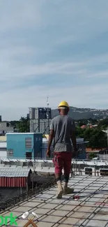 Construction worker on rooftop with city backdrop.