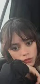 Young woman with pensive look in car.