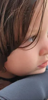 Close-up portrait of a child with soft brown hair looking pensive.