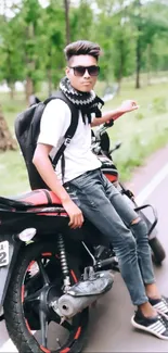 Young biker on motorcycle by a scenic road in nature.